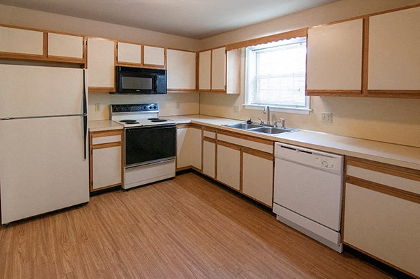 a kitchen with white appliances and wooden cabinets