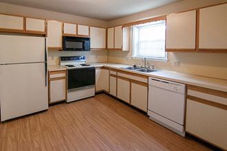 a kitchen with white appliances and wooden cabinets