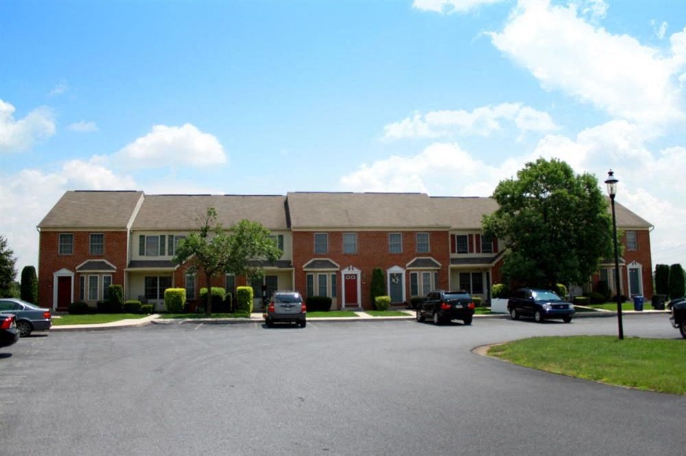 a large apartment building with cars parked in front of it