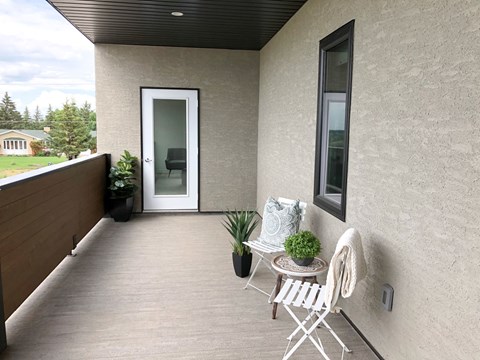 a balcony with a table and two chairs and a door