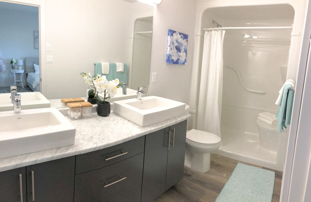 a bathroom with two sinks and a toilet and a shower