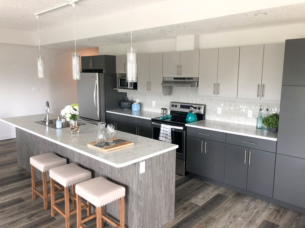 a kitchen with a large island with three stools