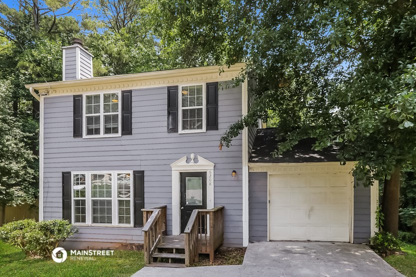 a gray house with a white garage door and a porch