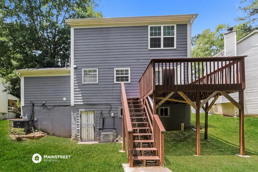the back of a house with a wooden deck and stairs