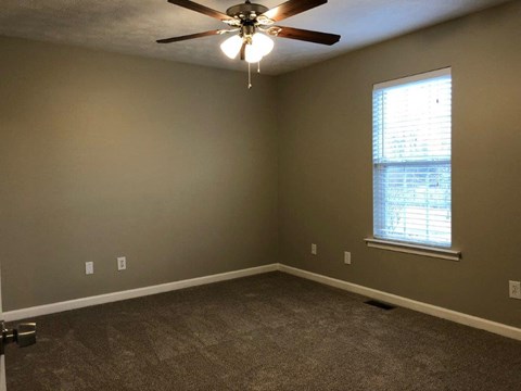 a bedroom with a ceiling fan and a window