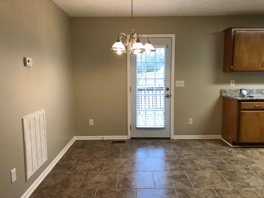an empty kitchen with a door to the living room