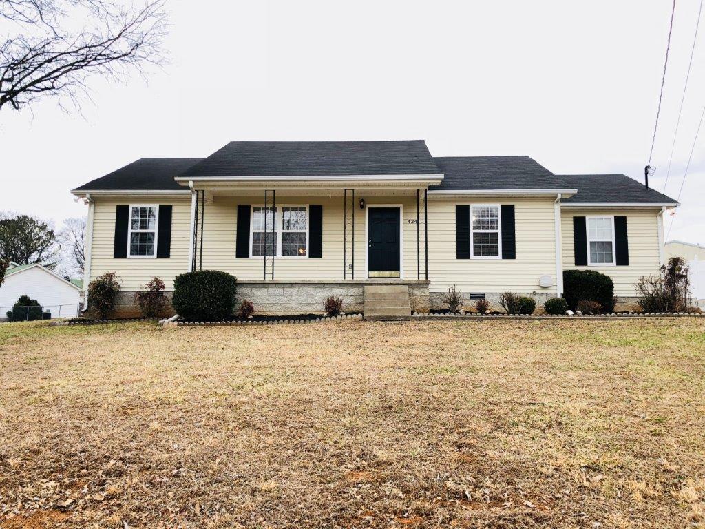 a white house with black shutters and a yard