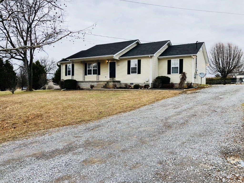 a white house with a gravel road in front of it