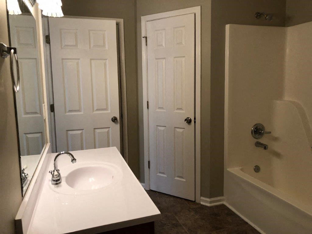 a bathroom with a sink and a shower and a door