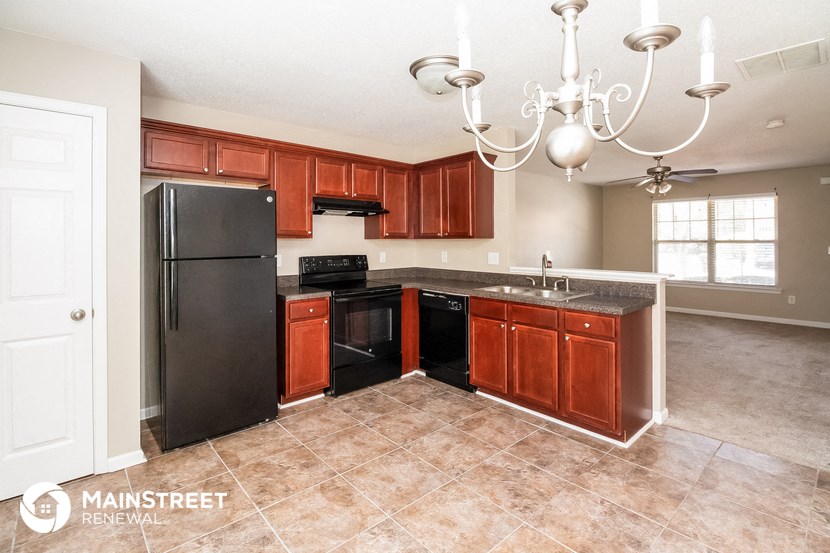 a kitchen with wooden cabinets and a black refrigerator