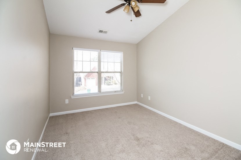 a bedroom with a ceiling fan and a window