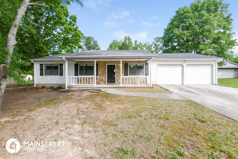 a white house with a porch and a garage door