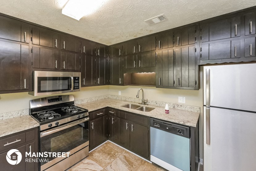 a kitchen with black cabinets and stainless steel appliances
