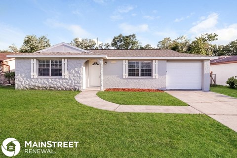 a small white house with a lawn and a sidewalk