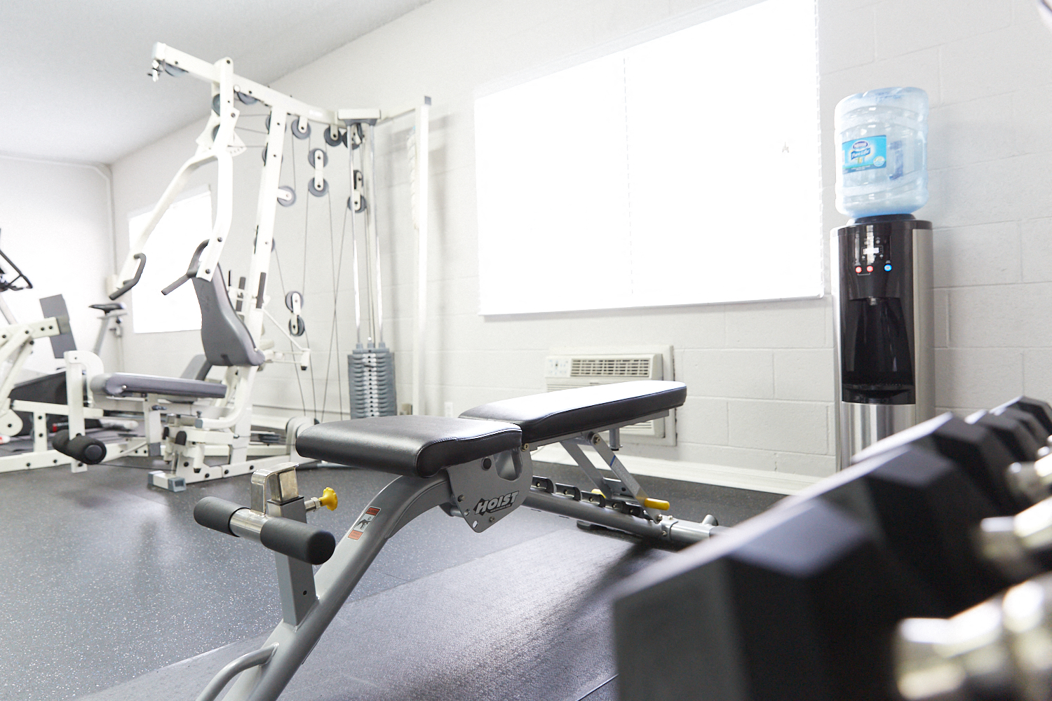 a gym with weights and a water bottle on a rack