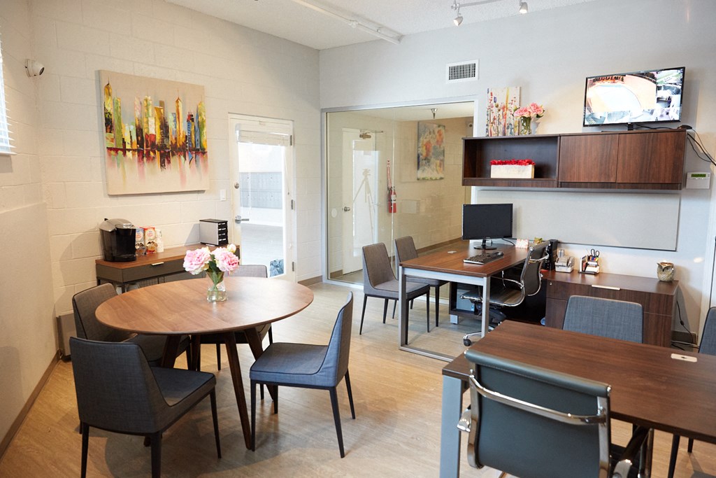 a conference room with tables and chairs and a television