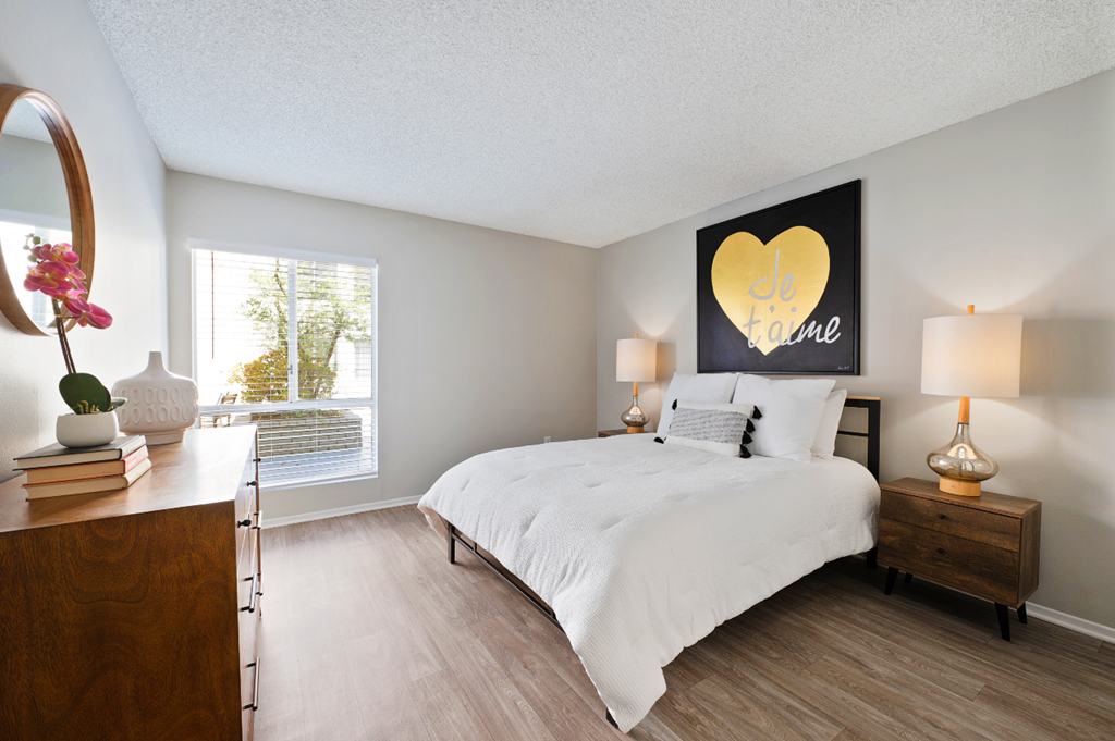 a bedroom with a bed and a dresser and a window