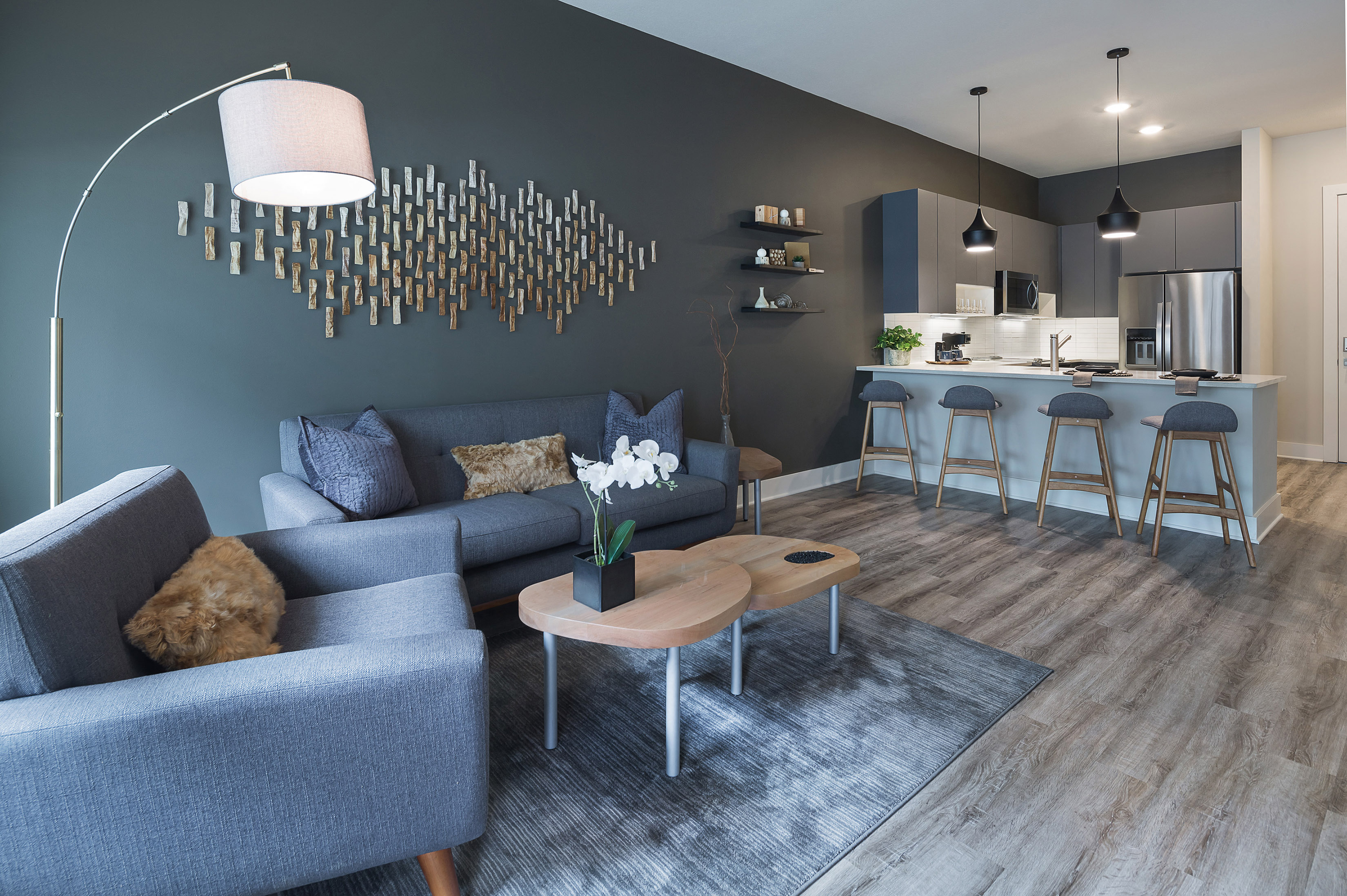 A modern living room with a grey couch and a wooden coffee table.
