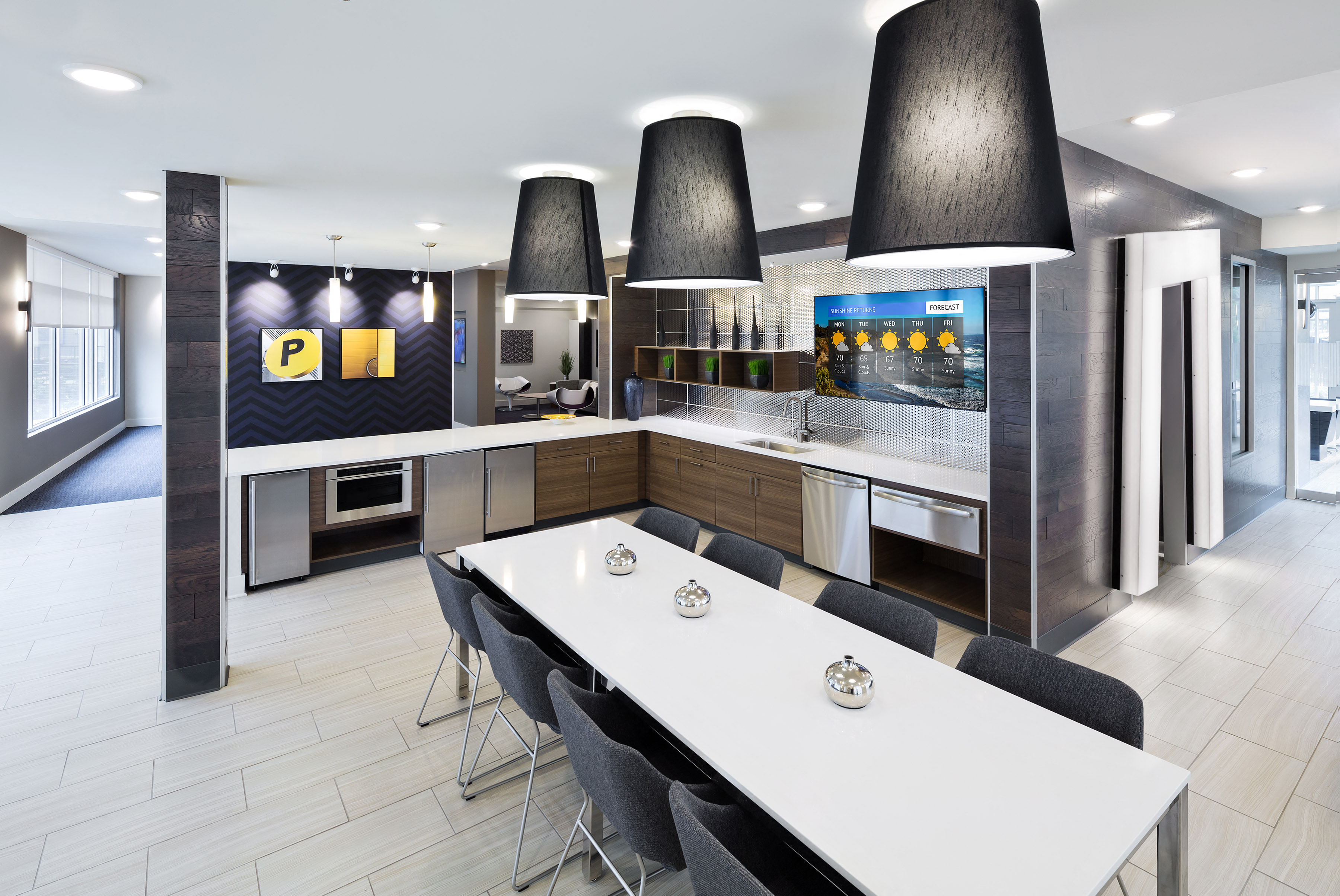 A modern kitchen with a white table and black chairs.