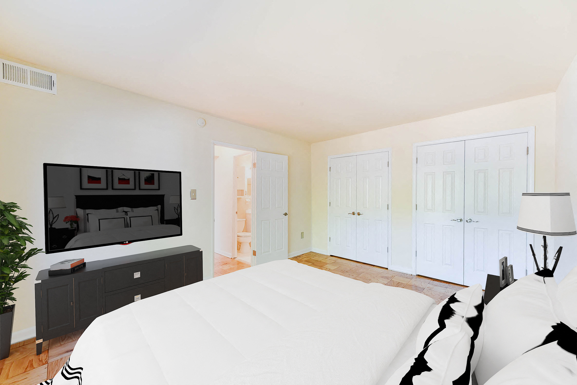 A bedroom with a large bed and a television.