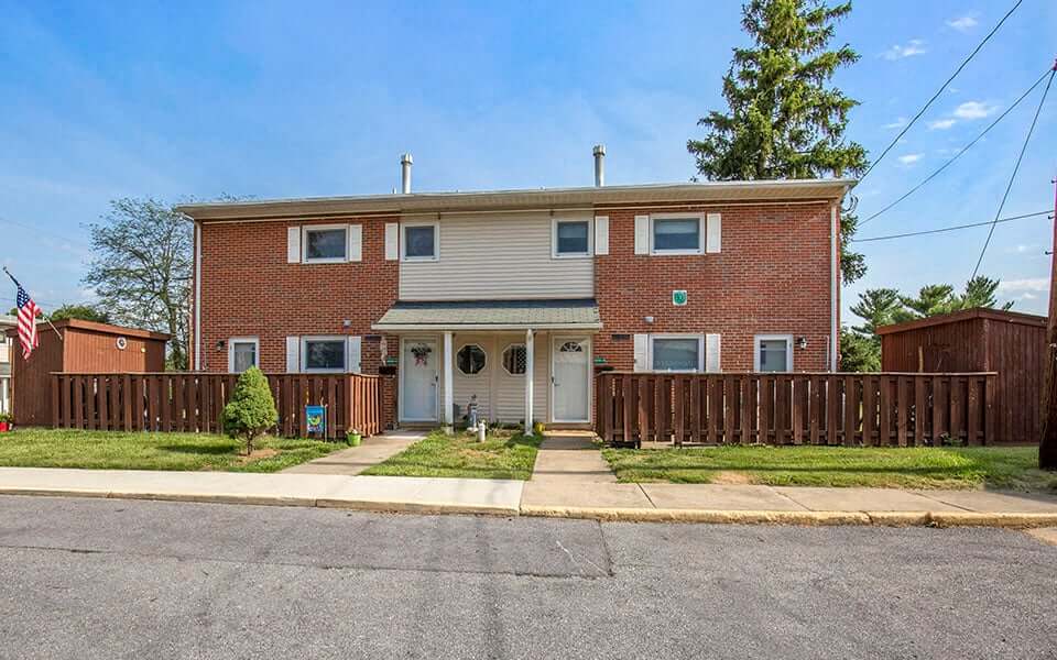 a red brick house with a wooden fence