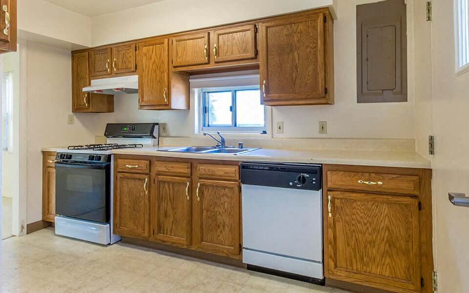 a kitchen with wooden cabinets and a stove and a sink