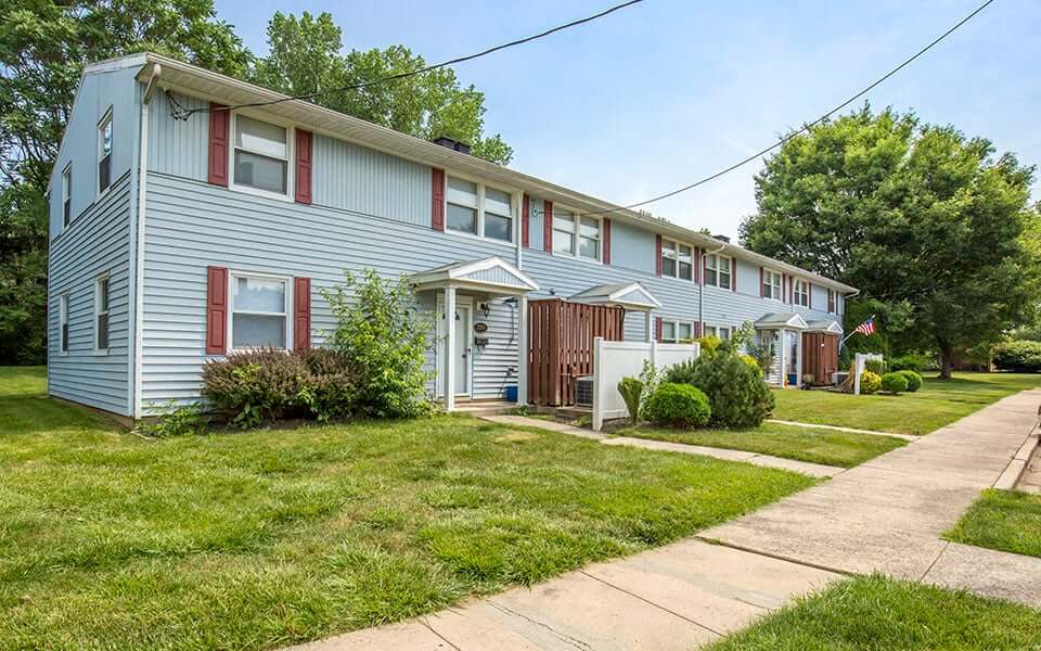 a blue house with a sidewalk in front of it