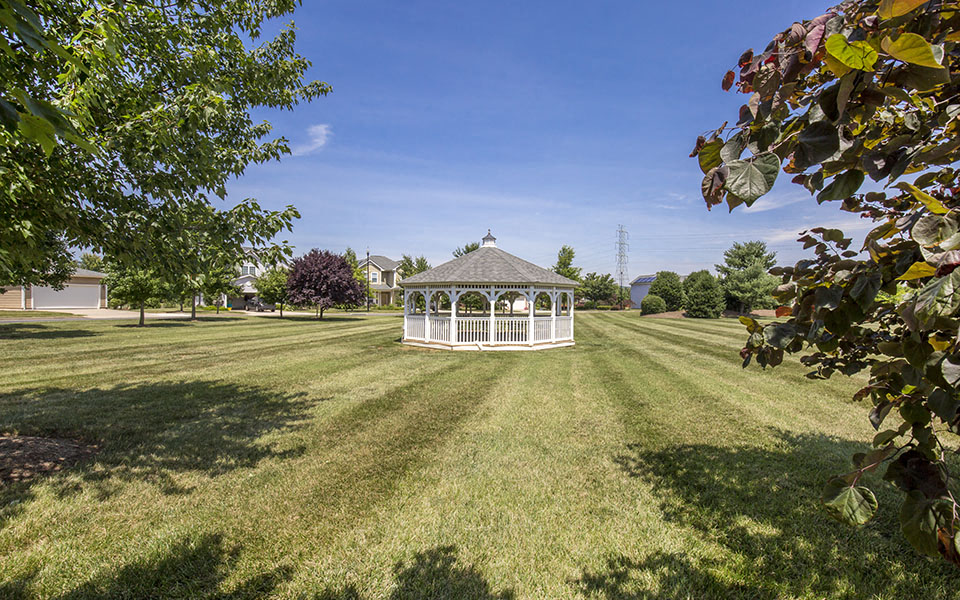 a white gazebo in the middle of a field