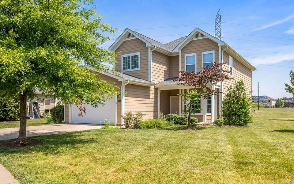 a house with a lawn and tree in front of it