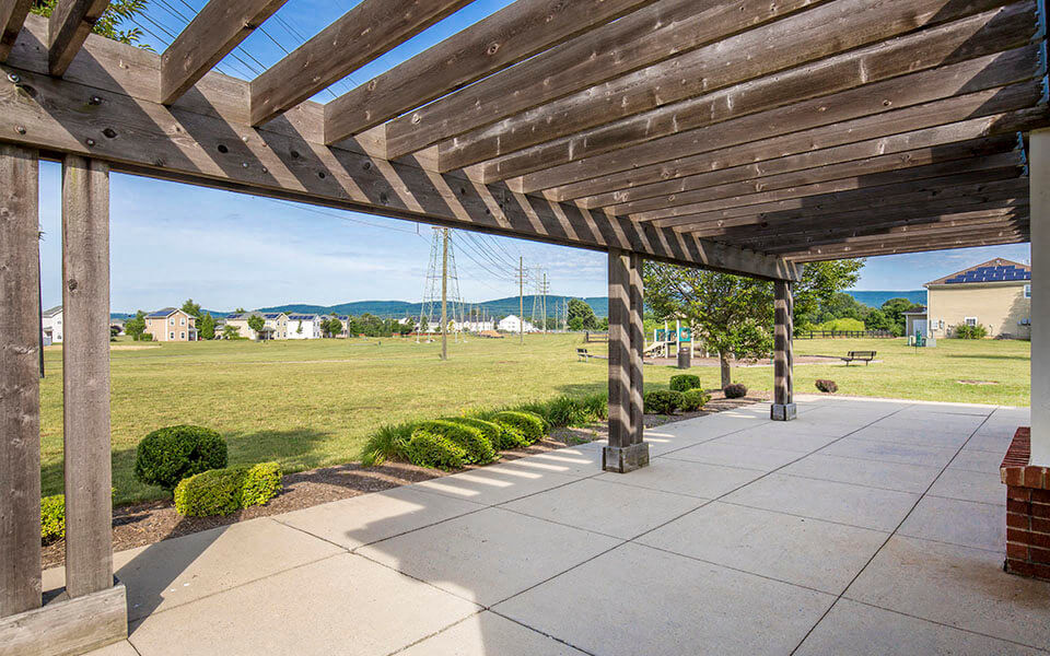 a covered patio with a view of a field