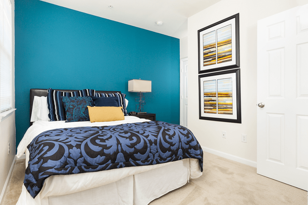 a bedroom with a bed and a blue wall