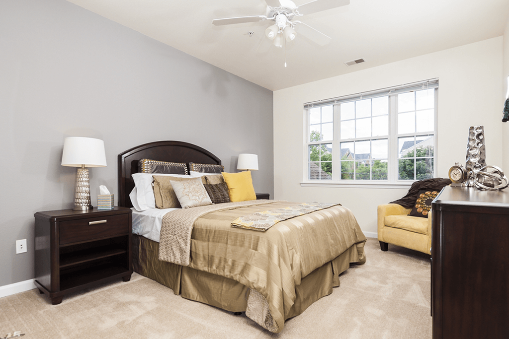 a bedroom with a bed and a ceiling fan