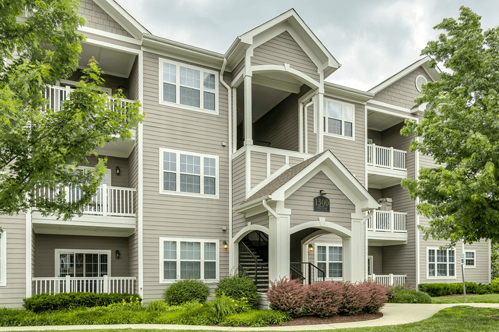 a large apartment building with a sidewalk in front of it