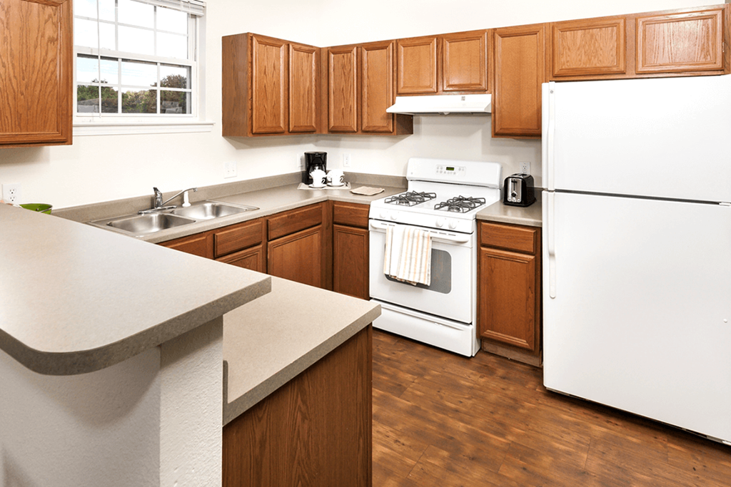 a kitchen with white appliances and wooden cabinets