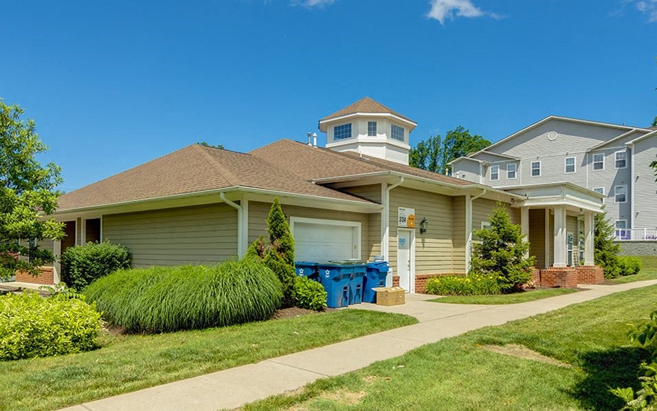 a beige house with a blue box on the sidewalk