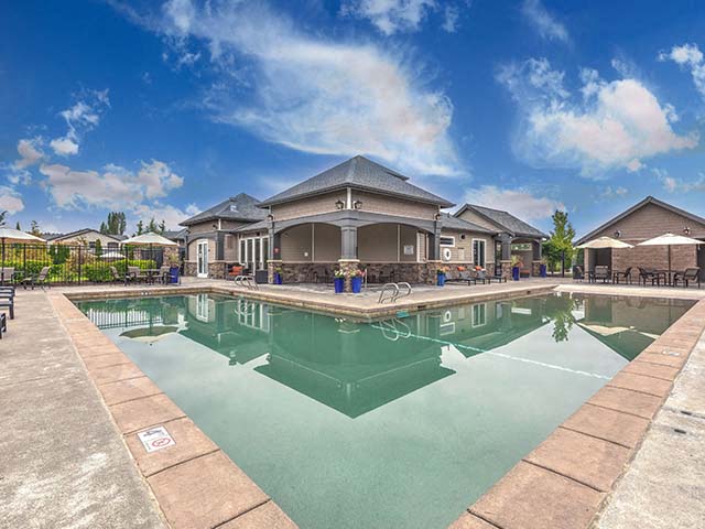 Fife WA Apartments - Bella Sonoma - Pool Area with Tables, Umbrellas, Planters, and Lounge Chairs