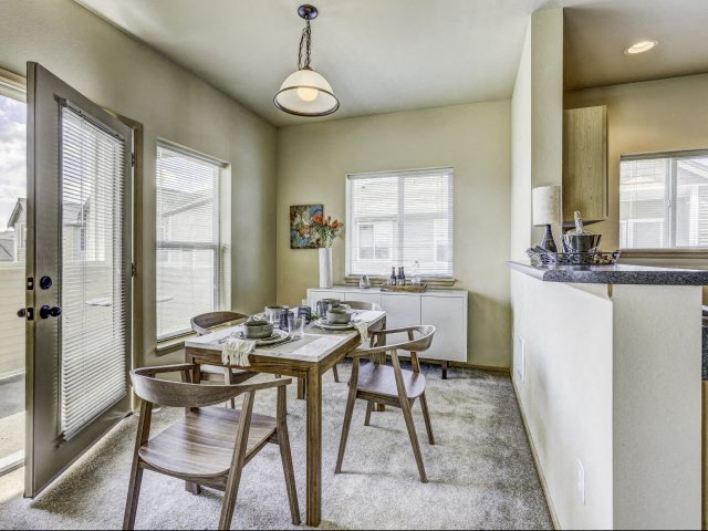 One to Three-Bedroom Apartments in Fife, WA - Bella Sonoma - Dining Room with Long Table, Patio Access, and Credenza