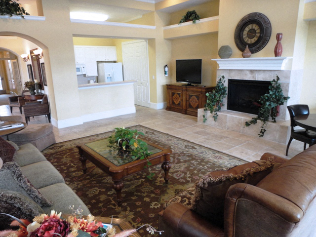 A living room with a brown leather couch and a glass coffee table.