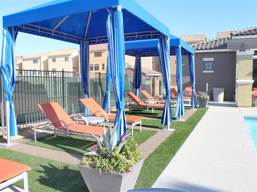 Poolside cabanas with lounge chairs on a sunny day