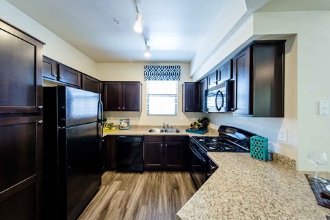 a kitchen with black appliances and granite counter tops