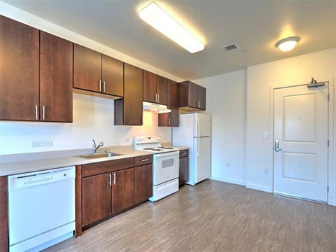 A kitchen with white appliances and wooden cabinets.