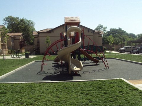 a playground with a slide on it in a park