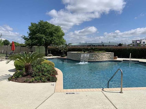 A pool with a waterfall and a sign that says "NO DIVING".