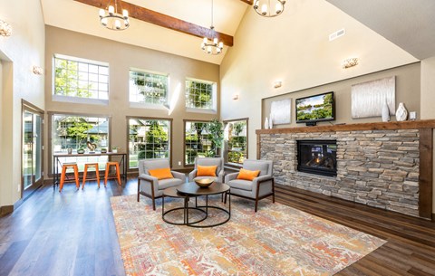 a living room with a stone fireplace and a table and chairs