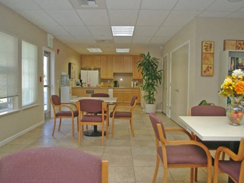 a dining room with tables and chairs and a kitchen