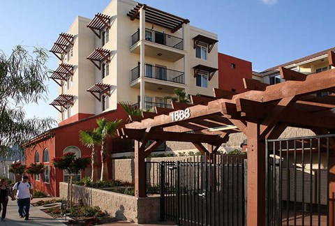 people walking in front of an apartment building