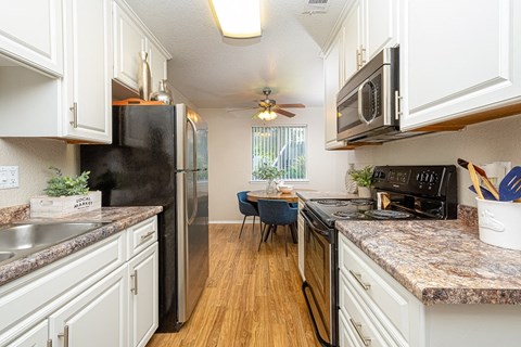 a kitchen with stainless steel appliances and white cabinets