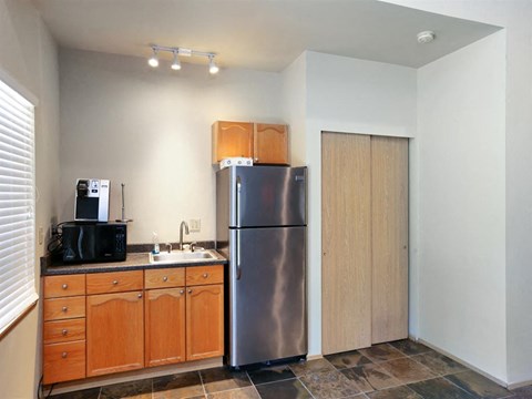 a kitchen with a stainless steel refrigerator and wooden cabinets