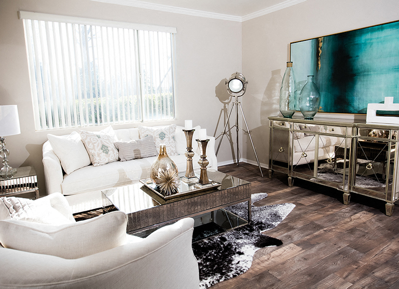 A living room with a white couch and a wooden floor.
