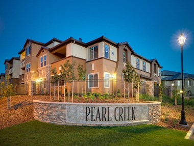 Roseville, CA Apartments - Exterior View of Pearl Creek Apartments Building Surrounded By Lush Landscaping with View of Entry Sign
